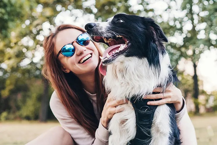young woman cuddling a dog